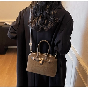 Vue détaillée du sac Boston en daim marron foncé avec boucle métallique et lanières en cuir