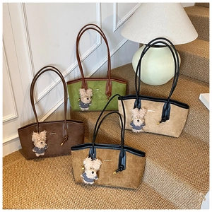 Gros plan de quatre sacs cabas en daim colorés avec charms ours sur un escalier moquetté