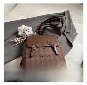 Detailed view of brown retro backpack with buckle straps and plaid texture