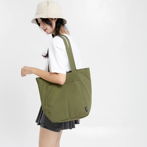 Vue détaillée du sac cabas en toile vert olive avec doubles poches avant pratiques