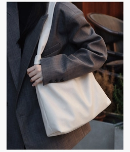Close-up of cream white large capacity tote bag with matte leather finish and wide strap