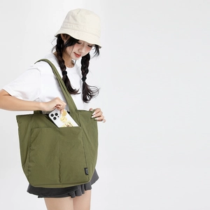 Gros plan du sac cabas en nylon vert militaire avec poche et bob en coton blanc
