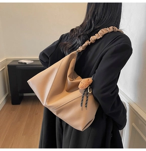 Détail du sac cabas marron avec bandoulière à volants et breloque ours en peluche