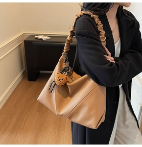 Sac à bandoulière en cuir caramel avec poignée plissée et détail de breloque ours