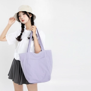 Détail d'un grand sac cabas lavande en nylon avec poche avant et bandoulière souple