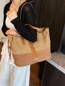 Large denim tote bag in tan and brown dual-tone with leather straps shown on model