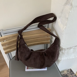 Detail of dark coffee suede crescent bag with knot shoulder strap and zipper