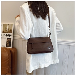 Detail view of deep brown vintage crossbody bag featuring silver hardware and grained leather