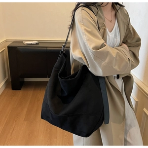 Detail of a large black canvas tote bag showing its spacious capacity and minimalist design