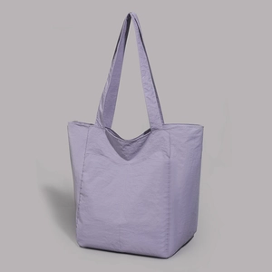 Détail du sac cabas en nylon violet clair montrant la texture durable et la poche avant