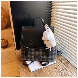 Detail view of plaid backpack with PU leather flap, brand embroidery and plush cat charm