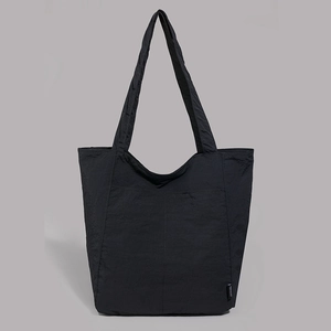 Gros plan du tissu en nylon imperméable texturé et des coutures sur le sac cabas noir