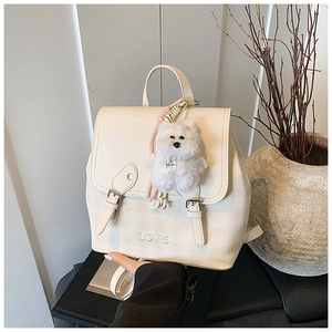 Detail of beige checkered PU leather backpack with plush puppy charm and embroidery