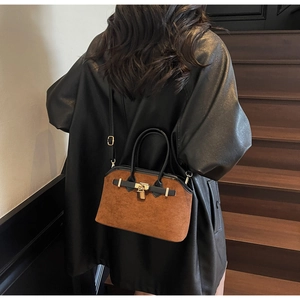 Vue détaillée du sac à main en daim marron avec boucle dorée et anses en cuir