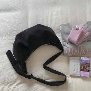 Detail of black crescent hobo bag with knotted strap and premium matte texture