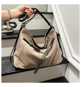 Detail of khaki suede hobo bag showing soft texture and contrast black strap detail