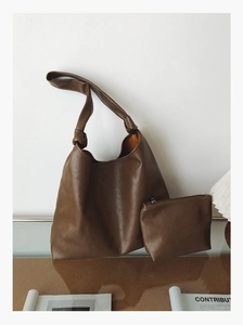 Detail view of large brown faux leather tote bag and matching inner pouch with knot strap