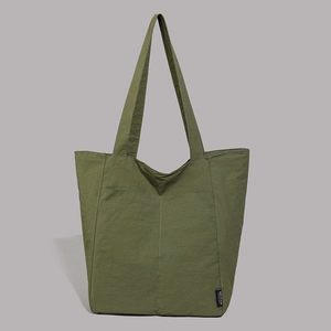 Vue détaillée du sac cabas en nylon vert olive avec coutures contrastées et étiquette logo