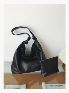 Detail view of black commuter tote bag set featuring knot shoulder strap and inner pouch