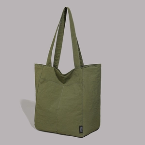 Détail du sac fourre-tout en nylon vert foncé montrant la texture du tissu résistant