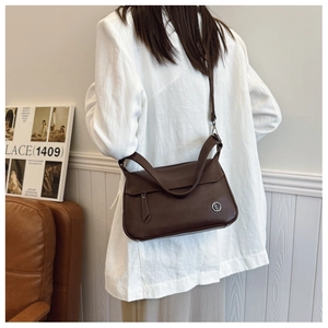 Detail of vintage brown square crossbody bag featuring front zipper pocket and adjustable strap