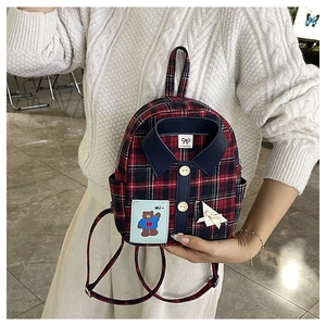 Detail of red and blue plaid backpack featuring shirt collar design and cute bear patch