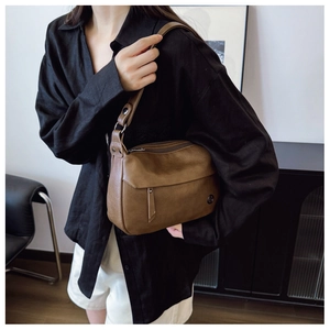 Detail of dark brown leather texture and zipper flap on vintage crossbody bag