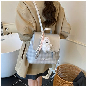 Fashionable women's grey plaid backpack with leather trim shown on a model