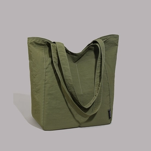 Détail du cabas en nylon vert armée avec surpiqûres blanches et étiquette latérale tissée