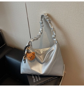 Détail du sac cabas argenté avec anse froncée et pendentif ours en peluche