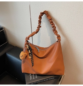 Sac hobo en cuir marron avec poignée plissée et breloque ours sur siège en cuir