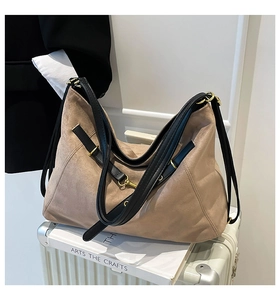 Detail of suede tote bag on a silver suitcase with high quality material and metal hardware