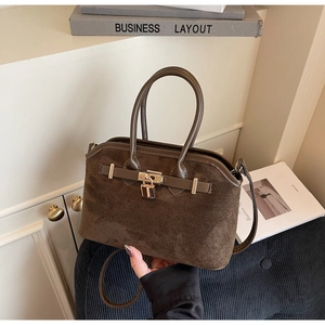 Vue détaillée du sac coquille en daim marron avec cadenas doré et poignées