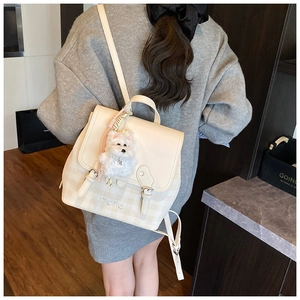 Detail of cream leather backpack with check pattern, brand logo and plush puppy charm