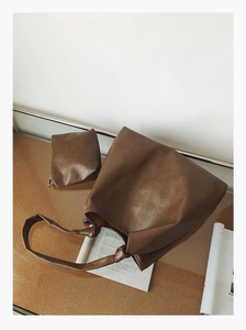 Detail of a vintage dark brown tote bag set with textured leather and a zipper pouch