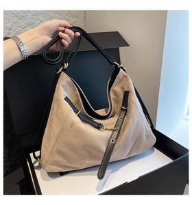 Detail of minimalist beige frosted leather tote bag with black strap and gold buckle