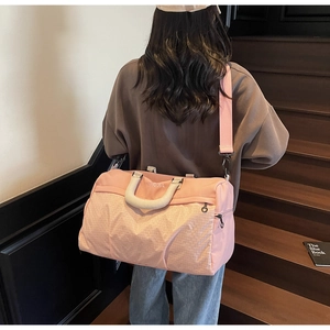 Pink travel bag with grid texture pattern shown from back view on a model