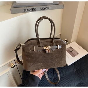 Détails du sac en daim marron avec cadenas doré et doubles poignées de transport
