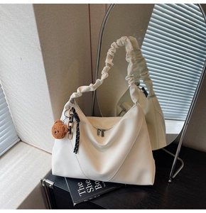 Détail du sac cabas blanc en cuir grainé avec anse froncée et breloque petit ours