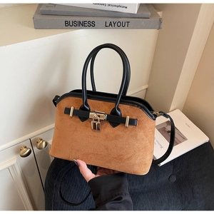 Vue détaillée du sac en daim caramel avec cadenas doré et accessoires de bandoulière