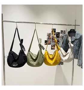 Détail de quatre sacs bandoulière demi-lune colorés avec nœuds et texture plissée
