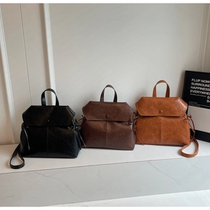 Three vintage faux leather backpacks in black, coffee, and caramel colors on a white surface