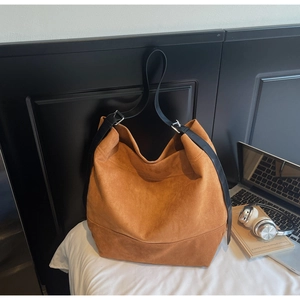 Texture détaillée du cabas en daim marron avec bandoulière en cuir noir en décor quotidien