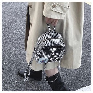 Detail of checkered tote bag with shirt collar design and cute bear patch decoration