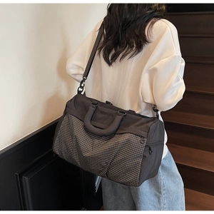 Detail of the durable grey mesh fabric and reinforced handles of this large travel bag