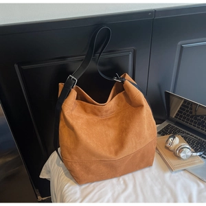 Detail of caramel suede tote bag with adjustable leather strap and spacious interior