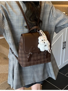 Brown checkered leather backpack for women featuring a flap cover and cute plush puppy charm