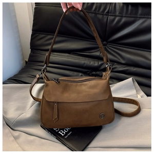 Detailed view of brown retro small square bag with metal logo and dual shoulder straps