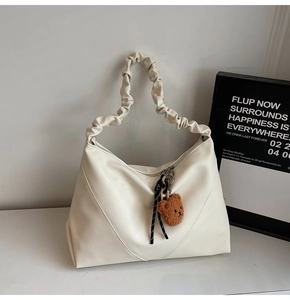 Détail du sac cabas blanc avec bandoulière plissée et breloque ours en peluche