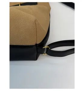 Close-up of golden hardware buckle and leather stitching on vintage brown tote bag